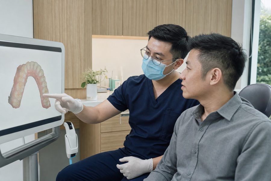 A dentist and patient looking at an intraoral scan on screen