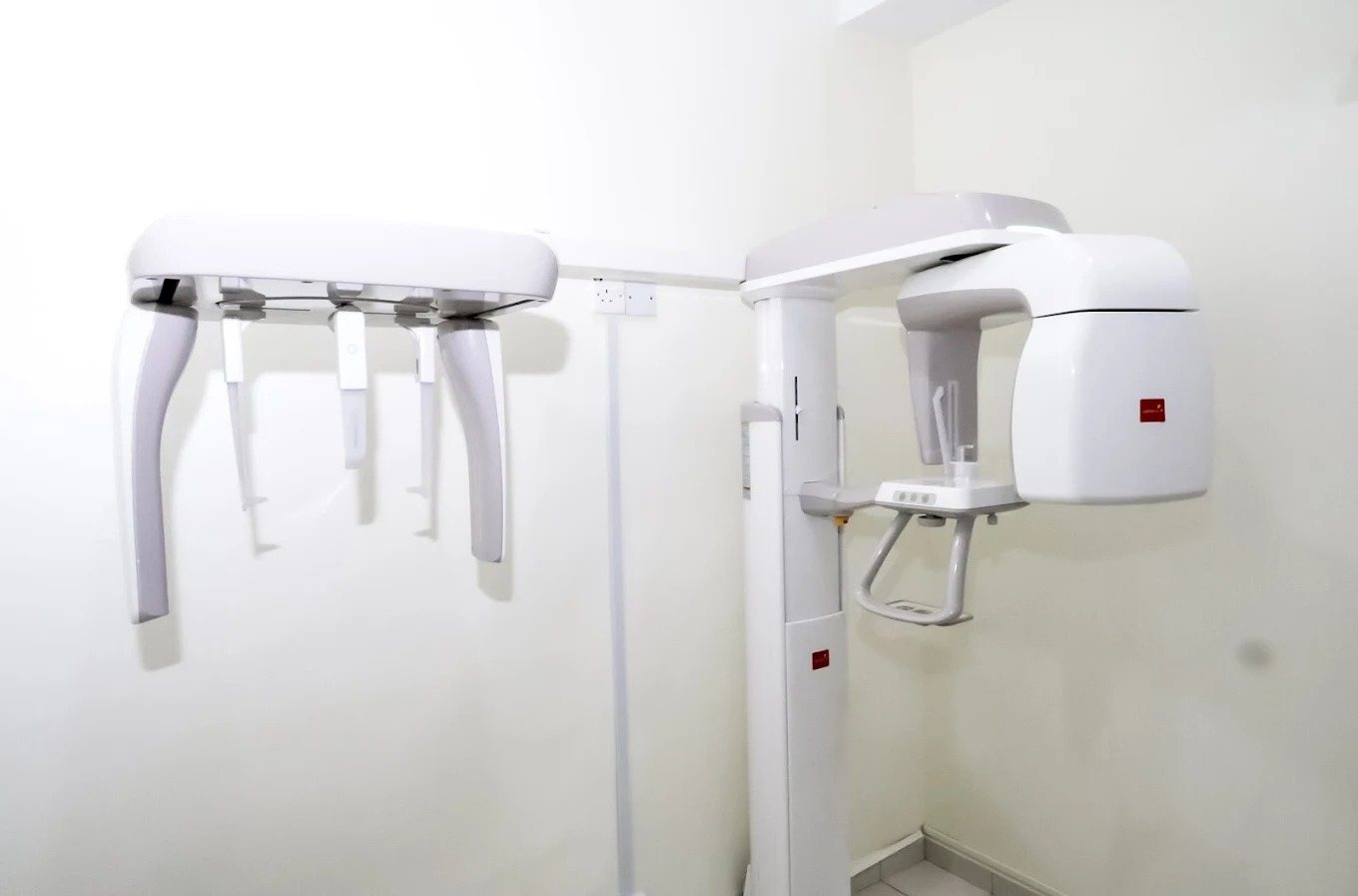 The imaging room at Ooi Dental: a panoramic and cephalometric X-ray unit against a white wall