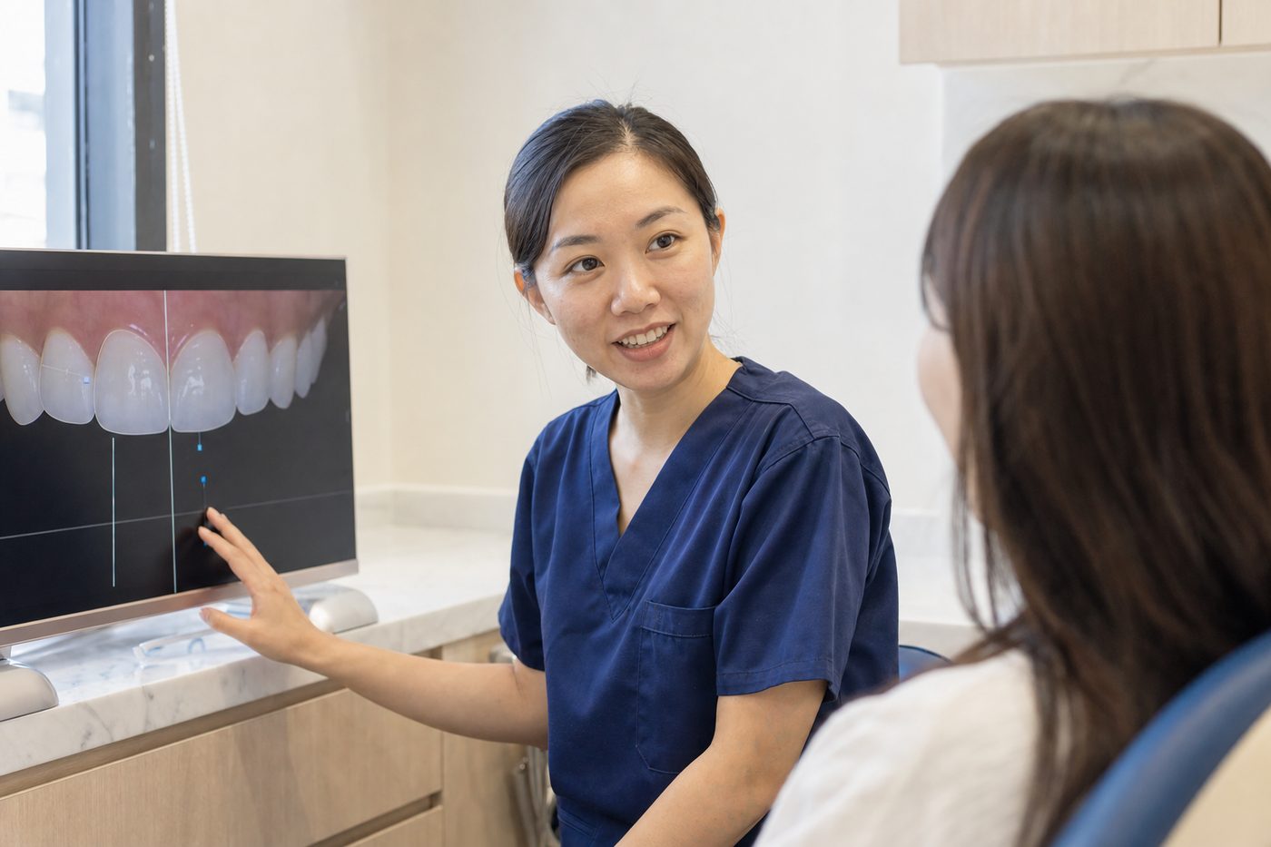 A dentist showing a patient a smile design on screen